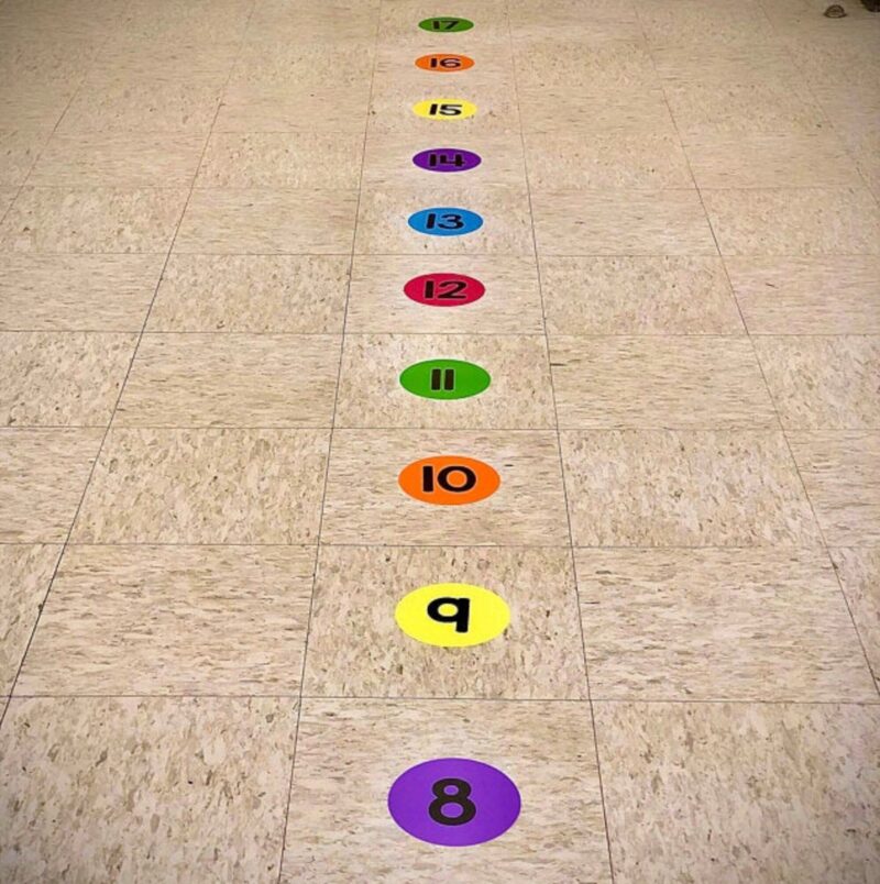number stickers on the floor in different colors for students to step on while lining up 